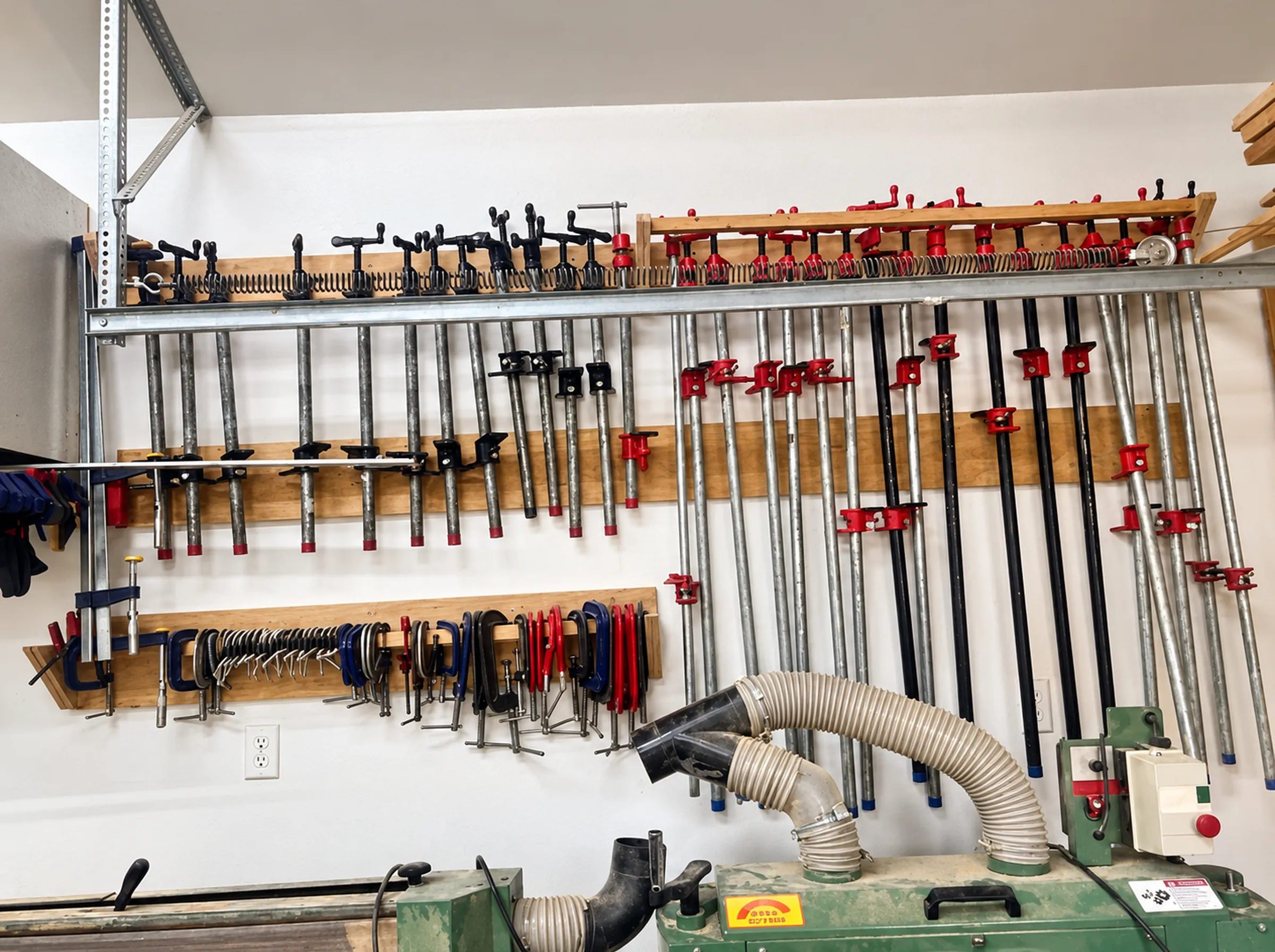 Mur de serres et tour à bois dans l'atelier d'ébénisterie de Sylvain Ouimet